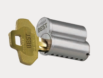 Brass key labeled BEST beside a silver cylindrical lock, shown in perspective.