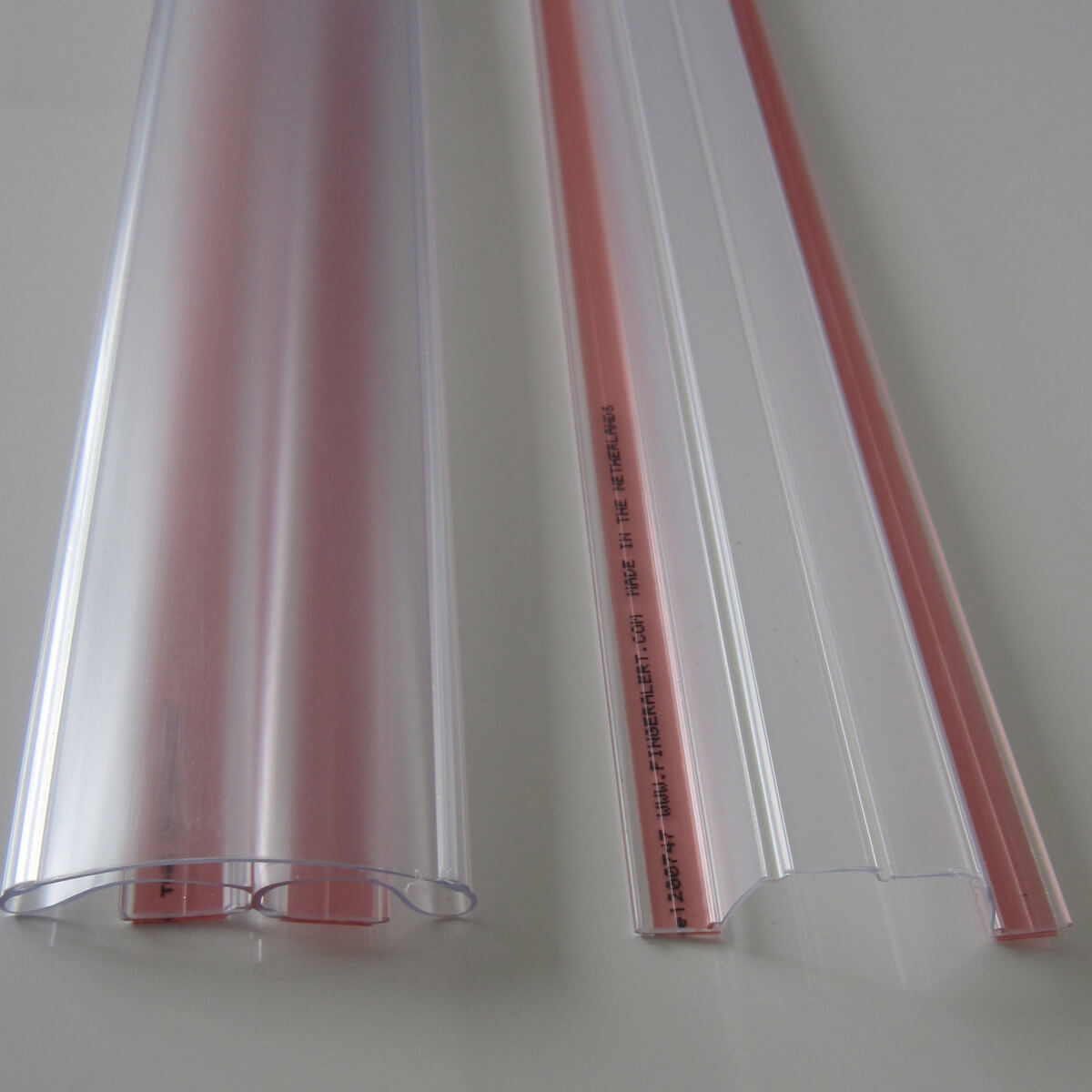 Clear door finger guards lying on white surface.