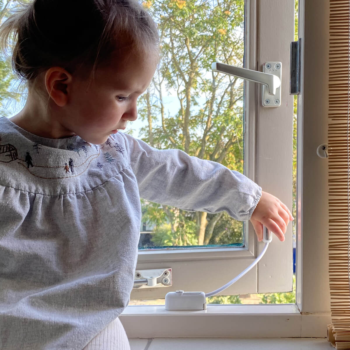 Child interacting with window security device.