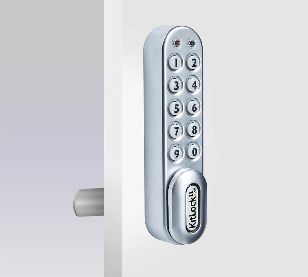 Silver keypad lock on white door, angled view.