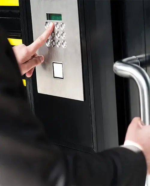 Person entering code on security keypad door lock.